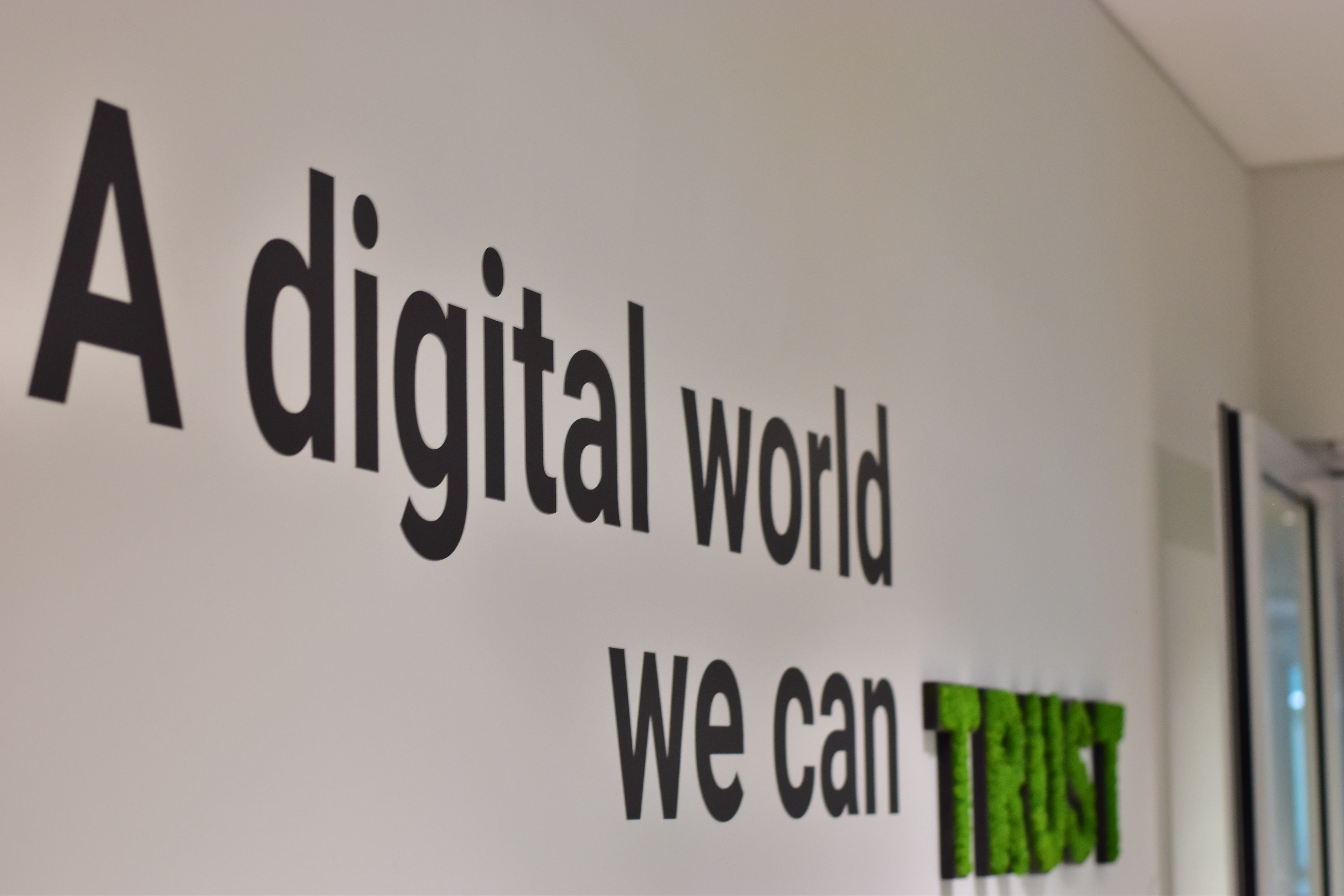 Uma foto do escritório da Trusted Shops com o slogan na parede « A digital world you can trust » (Um mundo digital em que pode confiar)