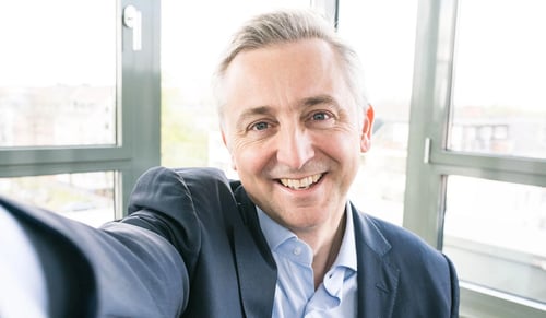 O CEO da Trusted Shops, Jean-Marc Noël, sorri para a câmara enquanto tira uma selfie no seu escritório.
