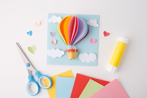 Papel colorido, tesoura, cola em bastão. Conceito de artesanato DIY e arte em papel para design, fornecimento de materiais criativos, projetos educativos para crianças, vista superior.